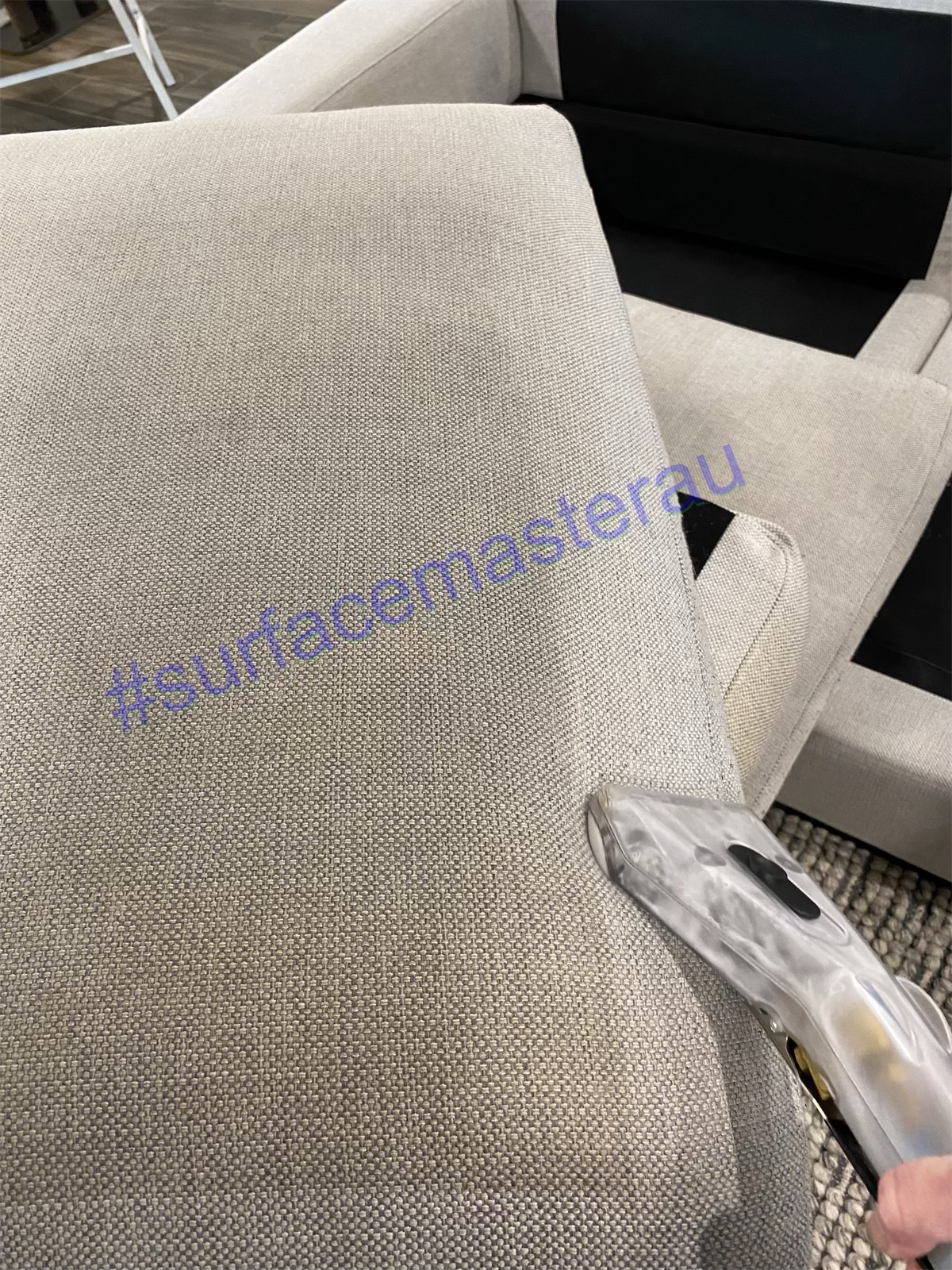 Upholstery cleaning wand on a fabric lounge
